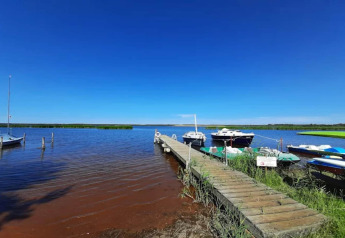 Ponton en bois avec bateaux amarrés à Houseboat «am Gräbendorfer See» sous ciel bleu en Allemagne.