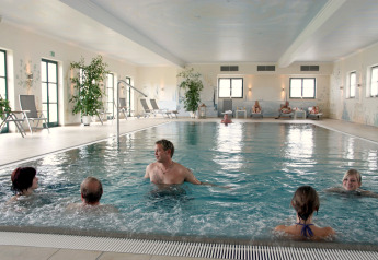 Piscina coperta nel Chalet «Bungalow» in Germania, con persone che si rilassano e si godono l’acqua insieme.