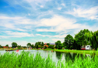 Vista panoramica di lago e verde al Chalet «Bungalow» in Germania, con persone che si godono la natura.
