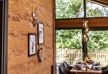 Arredo interno di Chalet «Bungalow» in Germania con parete in legno, quadri di cervo e zona pranzo.