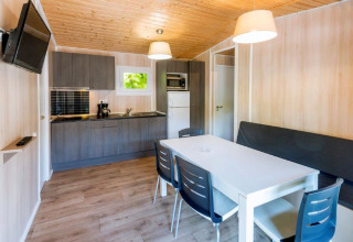 Cucina moderna e zona pranzo nel mobil home Camping Solmar XALET CONFORT in Spagna, interno in legno.