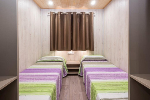 Due letti singoli in una stanza luminosa nella casa mobile Camping Solmar - XALET CONFORT in Spagna.