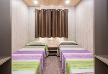 Twee enkele bedden in een lichte kamer van mobilhome Camping Solmar - XALET CONFORT in Spanje.