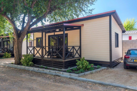 Stacaravan Camping Solmar - XALET CONFORT in Spanje, met voorterras, boom en parkeergelegenheid.