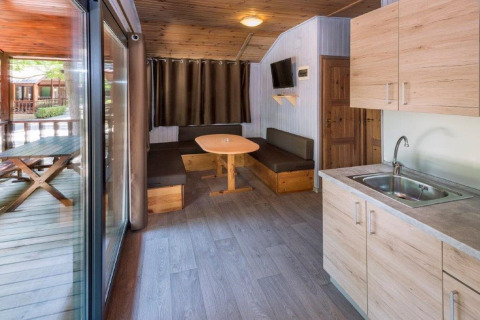 Indvendig udsigt af et hyggeligt sommerhus på Camping Solmar med køkken, spiseplads og terrasse i Spanien.