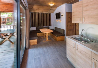 Vue intérieure d’un chalet confortable au Camping Solmar avec cuisine, coin salon et terrasse en Espagne.
