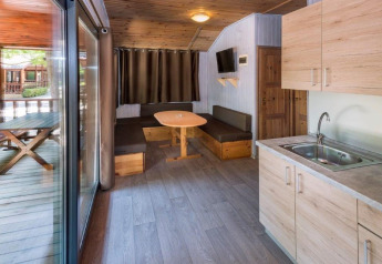 Indvendig udsigt af et hyggeligt sommerhus på Camping Solmar med køkken, spiseplads og terrasse i Spanien.