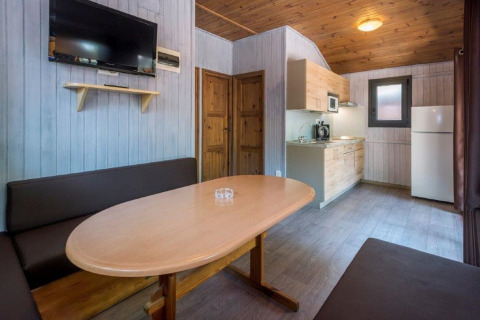 Vue intérieure du Camping Solmar - XALET en Espagne avec table à manger, cuisine et canapé.