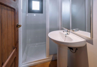 Salle de bain avec douche moderne, lavabo et miroir au lodge Camping Solmar - XALET en Espagne.