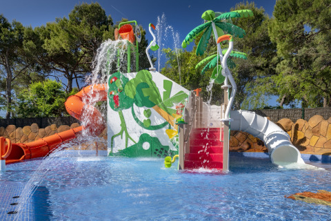 Aire de jeux aquatique avec toboggans, palmiers et jets d'eau au Camping Solmar - XALET en Espagne.