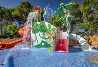 Aire de jeux aquatique avec toboggans, palmiers et jets d'eau au Camping Solmar - XALET en Espagne.