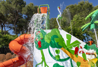 Parco giochi acquatico con scivolo arancione, secchio d’acqua e tema giungla al Camping Solmar - XALET CONFORT in Spagna.