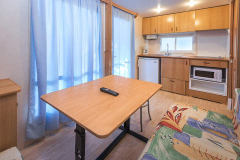 Interieur van een stacaravan op Camping Solmar - COTTAGE B in Spanje met keuken en eettafel.