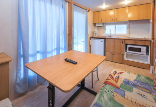 Indvendigt billede af mobilhome hos Camping Solmar - COTTAGE B i Spanien med køkken og spisebord.
