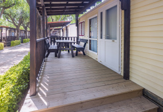 Houten veranda met zitbank bij Camping Solmar - COTTAGE B, een stacaravan in Spanje.