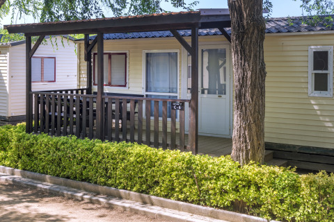 Stacaravan met houten veranda en heg, Camping Solmar - COTTAGE B, buitenaanzicht in Spanje