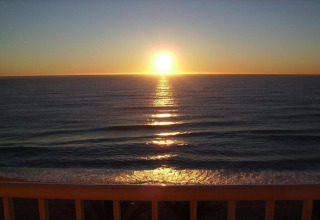 Zonsondergang boven zee vanaf het terras bij Camping Solmar - COTTAGE B, Spanje, met rustige golven.