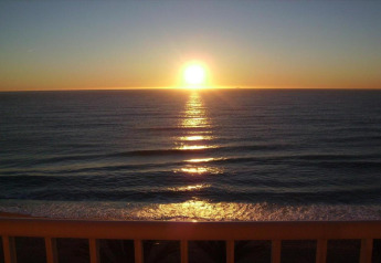 Tramonto sul mare visto dalla terrazza di Camping Solmar - COTTAGE B in Spagna, con le onde calme.