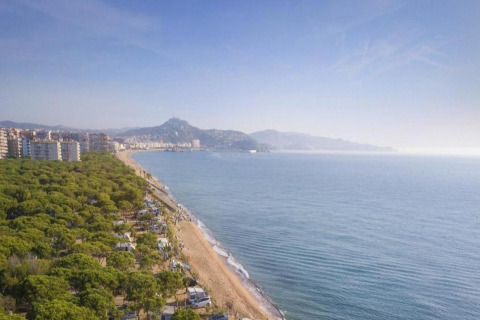 Uitzicht vanaf Camping Solmar - COTTAGE B in Spanje met kustlijn, strand, zee en groene natuur.