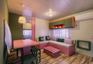 Woonkamer in Miramar Mobile Home CINQUE TERRE in Spanje met pastelkleuren, eettafel en moderne inrichting.