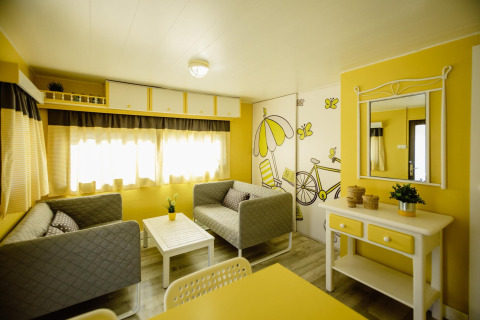 Woonkamer in Miramar Mobile home CINQUE TERRE, Spanje, met gele accenten en comfortabele sfeer.