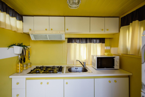 Lichte, compacte keuken in Miramar Mobile home CINQUE TERRE, Spanje, met gele en witte kleuren.