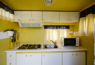 Lichte, compacte keuken in Miramar Mobile home CINQUE TERRE, Spanje, met gele en witte kleuren.