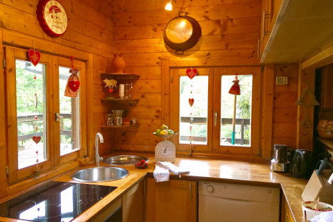 Cuisine chaleureuse en bois décorée de cœurs, chalet Remschweiler, en France, pleine de lumière.