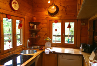 Gezellige houten keuken met hartdecoraties in chalet Remschweiler, Frankrijk, veel daglicht.