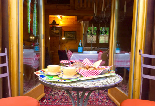 Table extérieure avec café et pain devant le chalet Remschweiler en France, décor chaleureux.