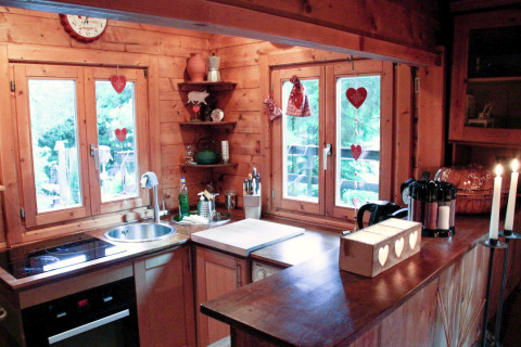 Cuisine chaleureuse de chalet Remschweiler en France, aux boiseries et décorations en forme de cœur.