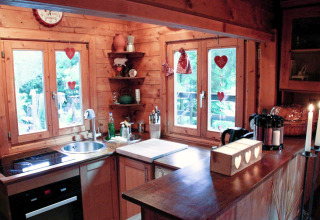Cuisine chaleureuse de chalet Remschweiler en France, aux boiseries et décorations en forme de cœur.
