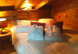 Gezellige chaletkamer in Remschweiler, Frankrijk, met tweepersoonsbed, badjassen en houten muren.
