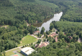 Luftfoto af Remschweiler chalet i Frankrig, omgivet af tæt skov og en flod, idylliske omgivelser.
