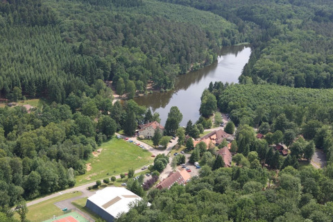 Luchtfoto van chalet Remschweiler in Frankrijk, omgeven door dicht bos en een kronkelende rivier.