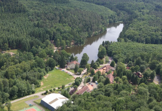 Luchtfoto van chalet Remschweiler in Frankrijk, omgeven door dicht bos en een kronkelende rivier.