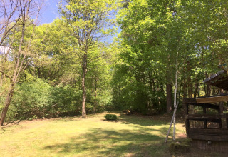 Arbres verts et herbe claire devant un chalet nommé « Remschweiler » en France par une journée ensoleillée.