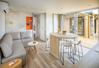 Moderne opholdsstue og spiseområde på Beach Resort «Agde 5» i Frankrig med sofa, bord og udendørs terrasse.