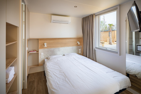 Moderne soveværelse på Beach Resort «Agde 5» i Frankrig med dobbeltseng, aircondition og vindue.