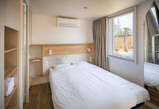 Moderne soveværelse på Beach Resort «Agde 5» i Frankrig med dobbeltseng, aircondition og vindue.