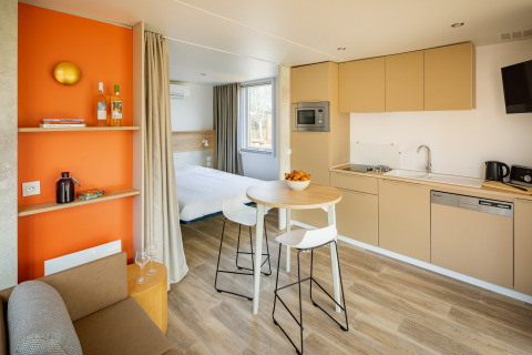 Moderne lodge ved Beach Resort Agde 5 i Frankrig med køkken, spiseområde og soveværelse i ét rum.