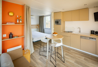Moderne lodge ved Beach Resort Agde 5 i Frankrig med køkken, spiseområde og soveværelse i ét rum.