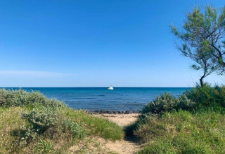 Udsigt til havet med en sejlbåd i det fjerne fra Beach Resort «Agde 4» mobilhome i Frankrig.