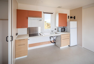 Moderne køkken i mobilhome Beach Resort «Agde 2» i Frankrig med ovn, køleskab og vindue.