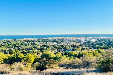 Udsigt over en frodig grøn by og det blå hav fra Beach Resort Agde 2 mobilhome i Frankrig.