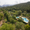 Aerial view of Huttopia Barcelona Pirineos glamping in Catalonia, surrounded by forest and a swimming pool.