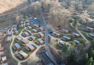 Luchtfoto van vakantiepark Hameau de la Semois in Belgisch Luxemburg, met houten huisjes in het groen.