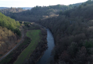 Luftaufnahme vom Fluss und Wald beim Ferienpark Hameau de la Semois in Luxemburg, Belgien.