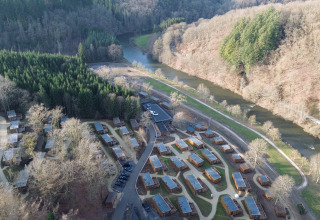 Luchtfoto van vakantiepark Hameau de la Semois in België, met huisjes, bos en de kronkelende rivier Semois.