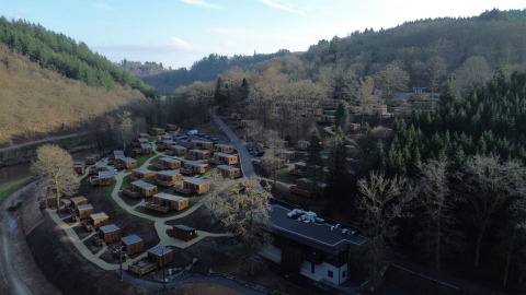 Luchtfoto van vakantiepark Hameau de la Semois in de beboste heuvels van Belgisch Luxemburg.